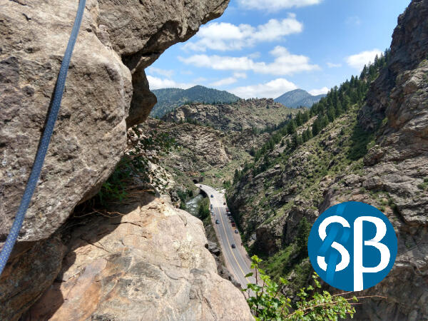 Clear Creek Climb View of Clear Creek road from a rocky cliff. Safety Beta logo on the bottom right corner of image.